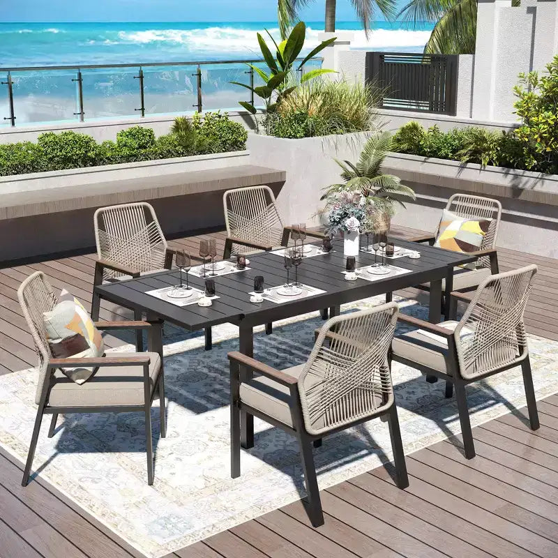 Set da pranzo da patio Captiva Designs da 7 pezzi, tavolo in acciaio con piano a doghe e sedie in rattan beige con cuscini